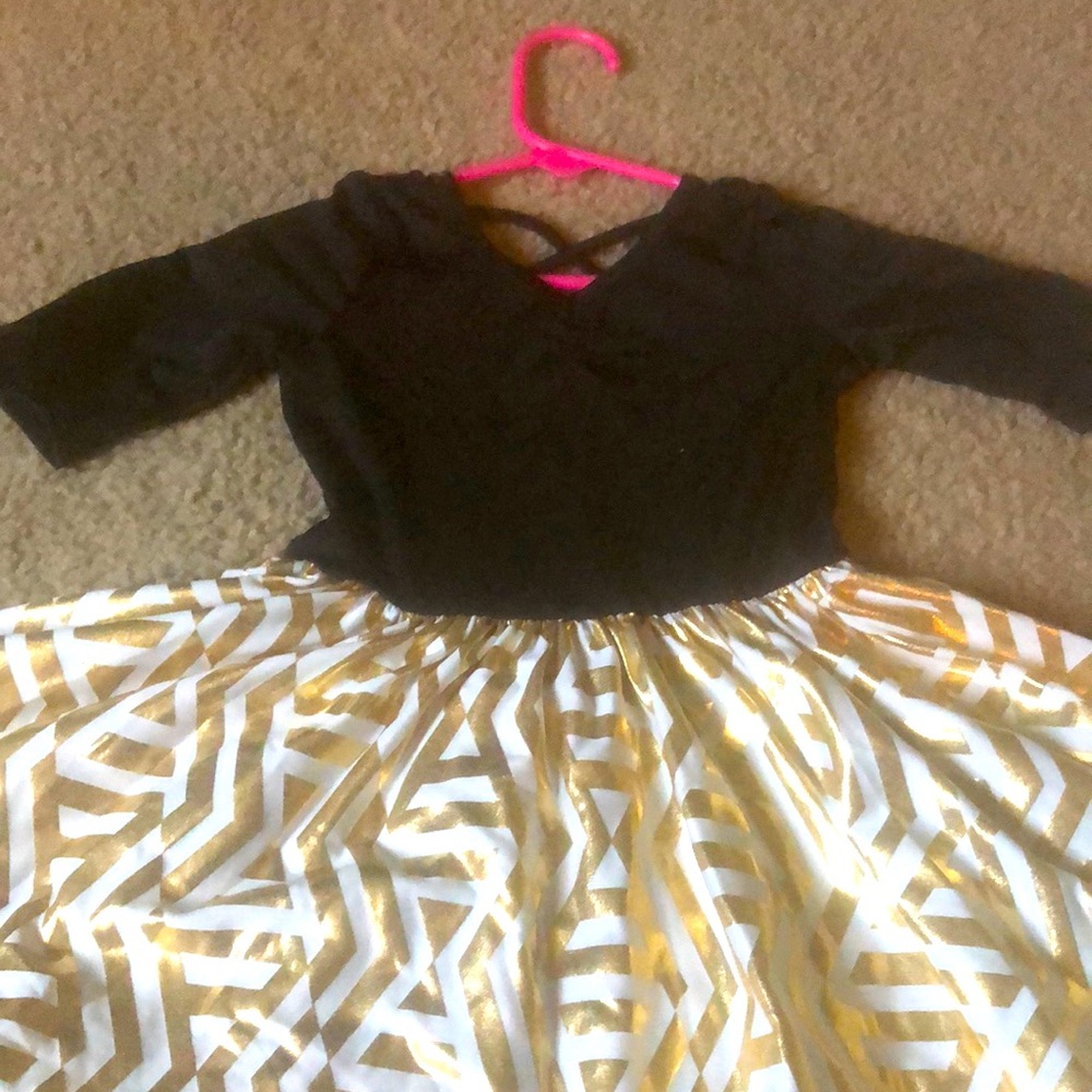 Is a 2T, golden bottom, black top, cross on back!
